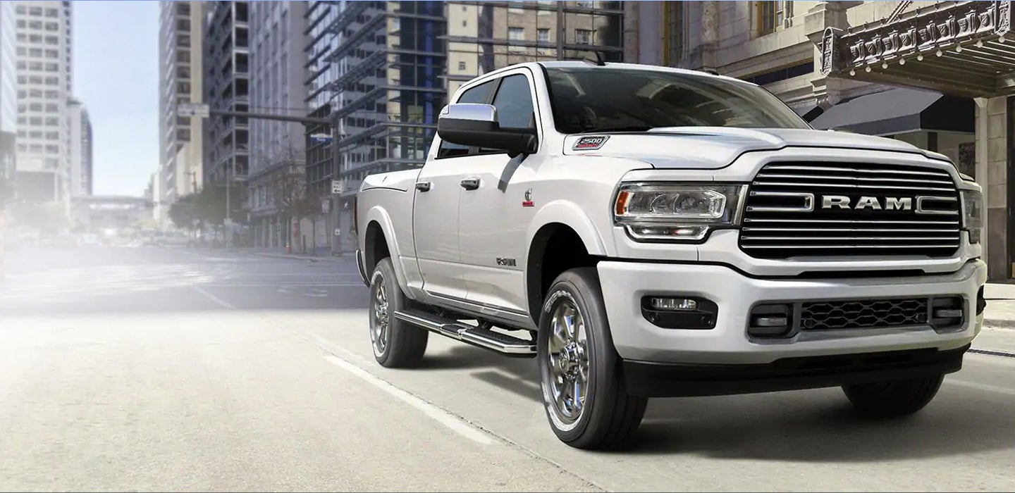 Image of a white 2019 RAM 2500 driving on a city street.